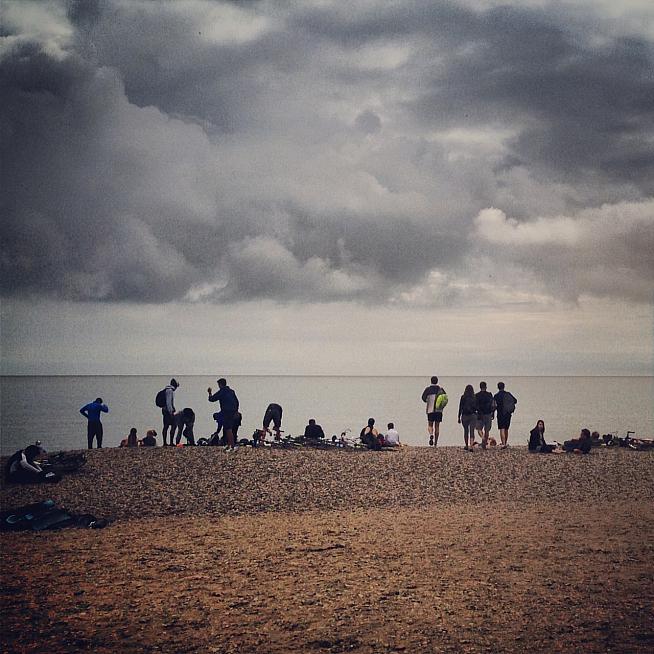 Beach life: riders enjoy a rest on the shingle after cycling overnight from London.