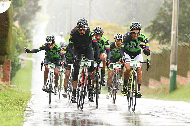 Riders at the head of the field throw up spray during CRM GFNY Colombia. Credit: sportgraf.com