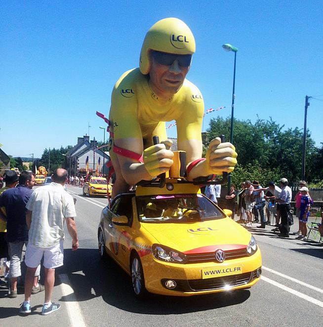 Chris Froome catches a ride in a team car. Or is it...?