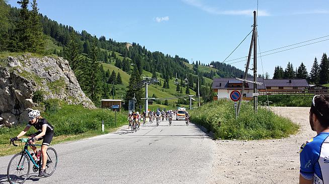 An ambulance squeezes past riders on the second ascent of the Campologno.