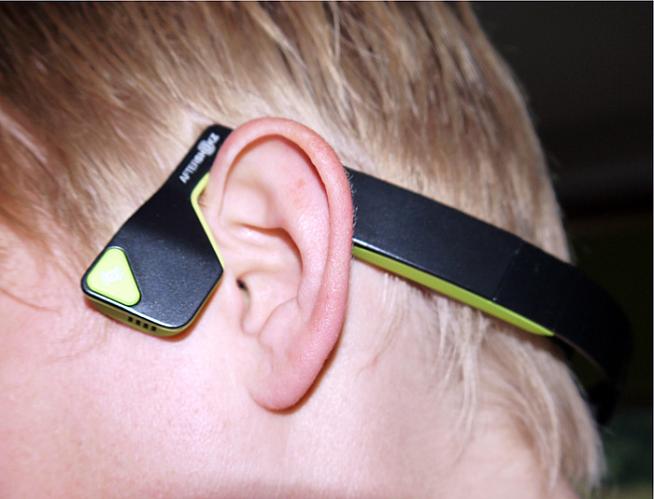 The AfterShokz wrap around the back of your head and don't interfere with a helmet - if you're wearing one.