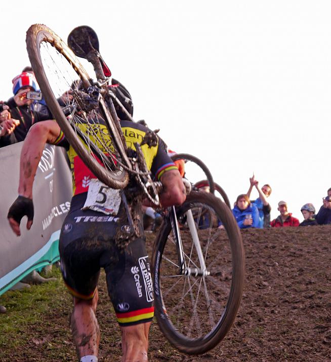 Shouldering his banjaxed steed up a muddy ramp.