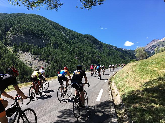 Riders stream up the early slopes of the Col d'Izoard.