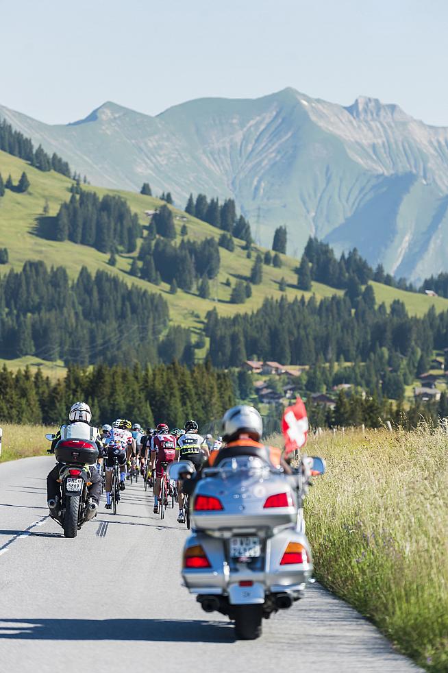 Moto outriders accompany the bunch as they roll through pristine Swiss real estate. Phil Gale / Emmie Collinge