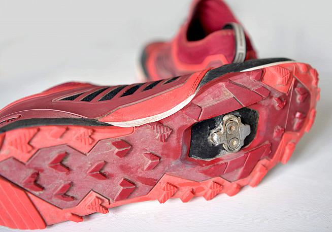 The soles feature a rugged tread with recessed mounting points for SPD cleats.