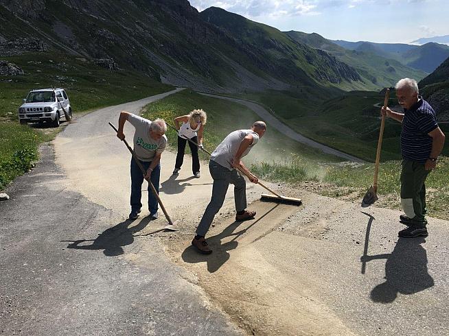 Volunteers at work repairing the road surface used by the granfondo.
