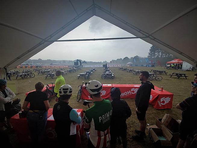 Cyclists take shelter while debating whether to ride the course anyway. Photo: Peter Levenspiel