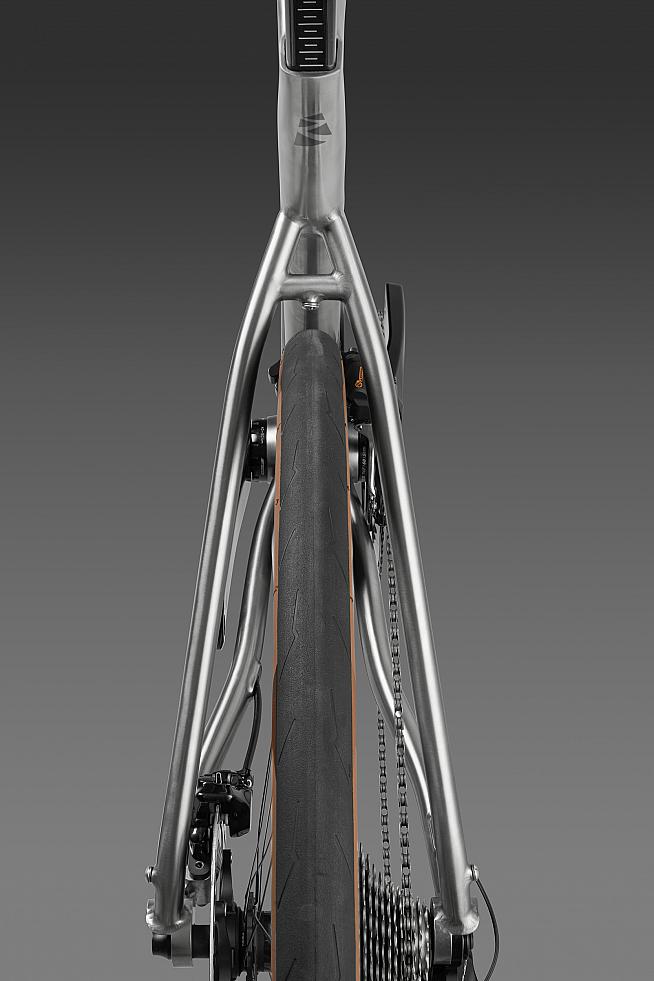 The titanium frame features brushed metal details and a D-shaped seat post for compliance.